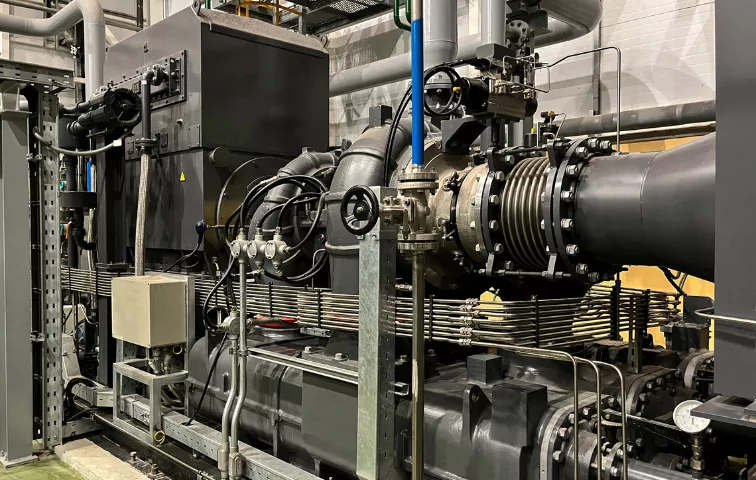 Sistema industrial de ar comprimido com múltiplas tubulações interconectadas, válvulas de controle manual e automatizadas, flanges robustas e manômetro de pressão. A instalação complexa demonstra uma rede de distribuição de ar comprimido de alta capacidade em ambiente industrial, evidenciando a importância da engenharia especializada e manutenção preventiva para garantir eficiência operacional.